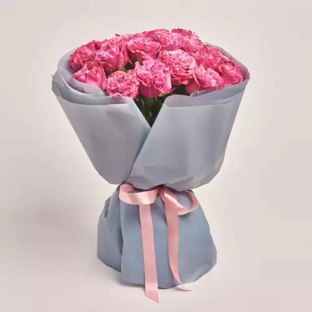 Tilted view of a document page with text alongside a gray gift bag with a pink ribbon.