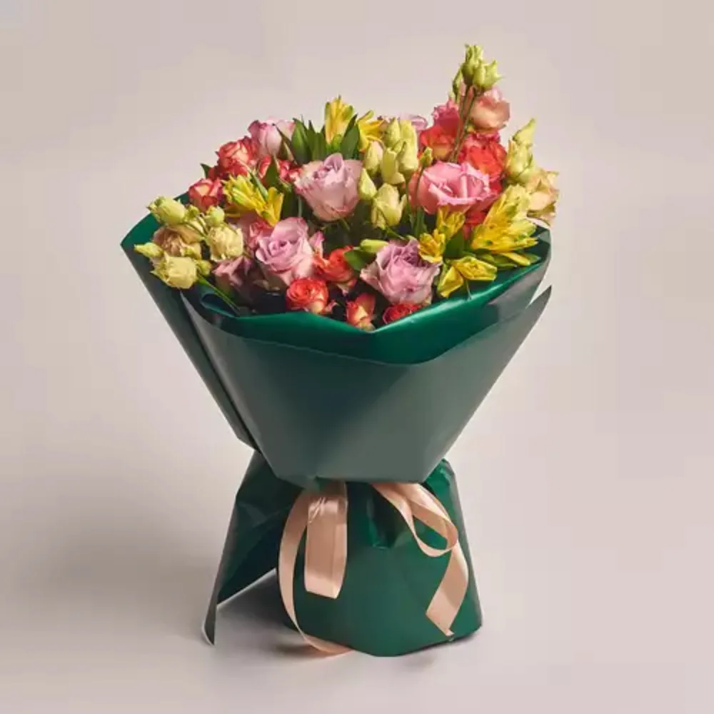 Elegant mixed rose bouquet in soft peach and pink tones, wrapped in nude paper and tied with a white ribbon
