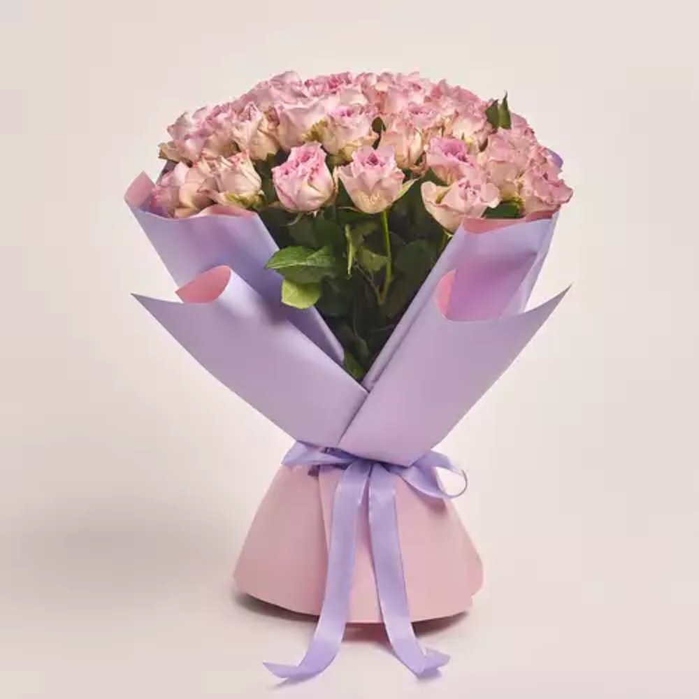 Soft pink rose bouquet wrapped in pastel lavender paper and tied with a matching ribbon