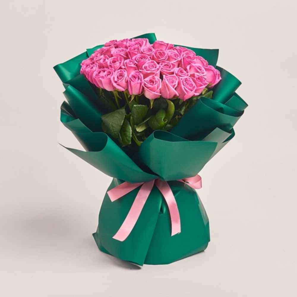 Elegant bouquet of fresh pink roses wrapped in premium green paper with a soft pink ribbon, perfect for gifting.