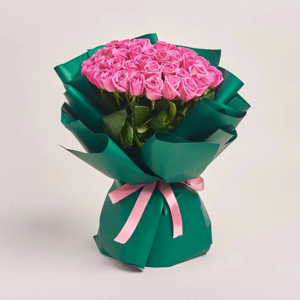 Elegant bouquet of fresh pink roses wrapped in premium green paper with a soft pink ribbon, perfect for gifting.