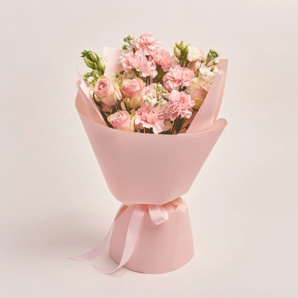 Elegant mixed flower bouquet with pink carnations, blush roses, and soft pastel blooms wrapped in pink paper, luxury floral gift by Favish Blooms Dubai