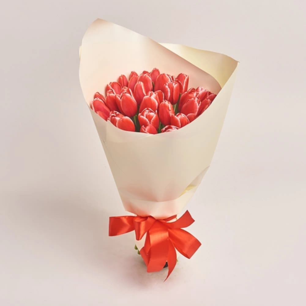 Fresh red tulip bouquet wrapped in cream paper with a red ribbon, elegant romantic flower gift by Favish Blooms Dubai
