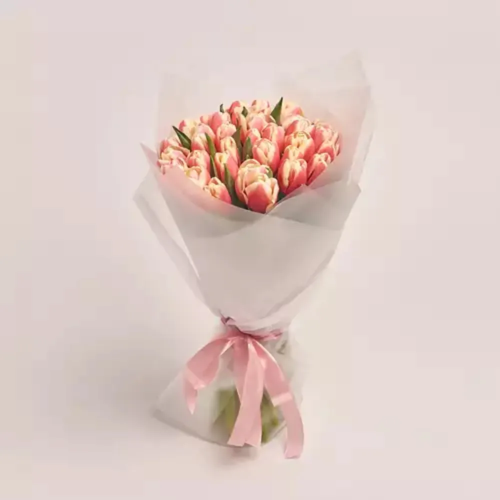 Elegant bouquet of pink and white tulips wrapped in white paper with a soft pink ribbon, premium floral gift by Favish Blooms Dubai