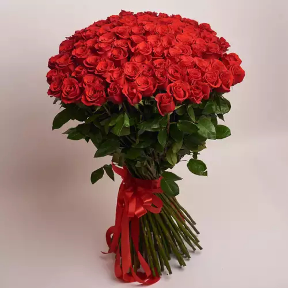 Large bouquet of fresh red roses arranged in a full dome style with green foliage and a red ribbon, luxury romantic flower gift by Favish Blooms Dubai