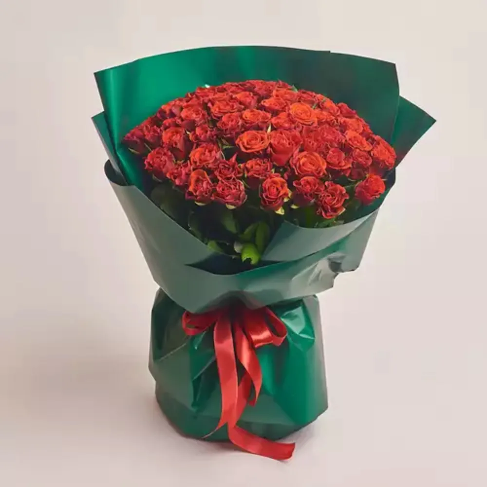 Luxury bouquet of fresh red roses wrapped in premium green paper with a red ribbon, elegant romantic flower gift by Favish Blooms Dubai