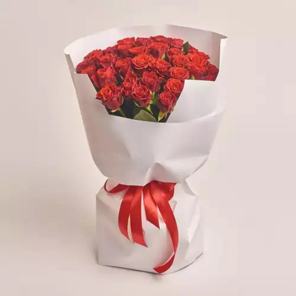 Elegant bouquet of fresh red roses wrapped in white paper with a red ribbon, premium romantic flower gift by Favish Blooms Dubai