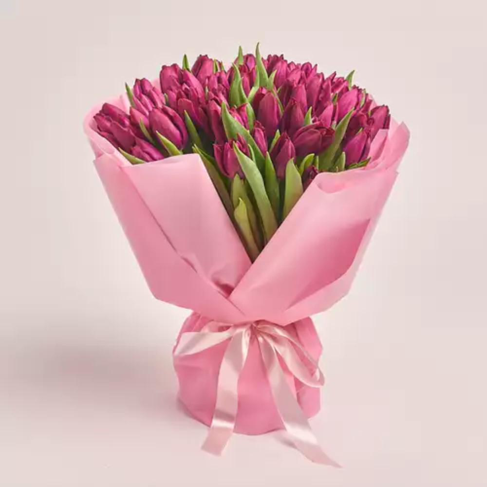 Luxury bouquet of fresh purple tulips wrapped in soft pink paper with a satin ribbon, elegant floral gift by Favish Blooms Dubai