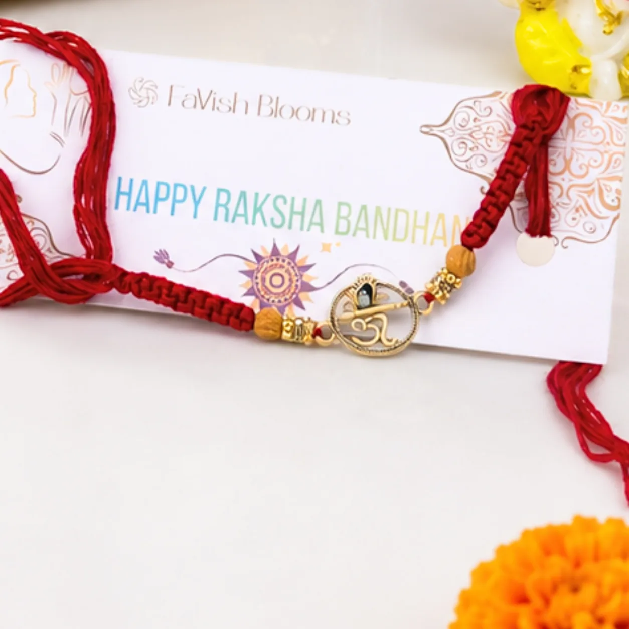 Lord Ganesha idol placed beside premium Ferrero Rocher chocolates and an Om Rakhi for Raksha Bandhan.