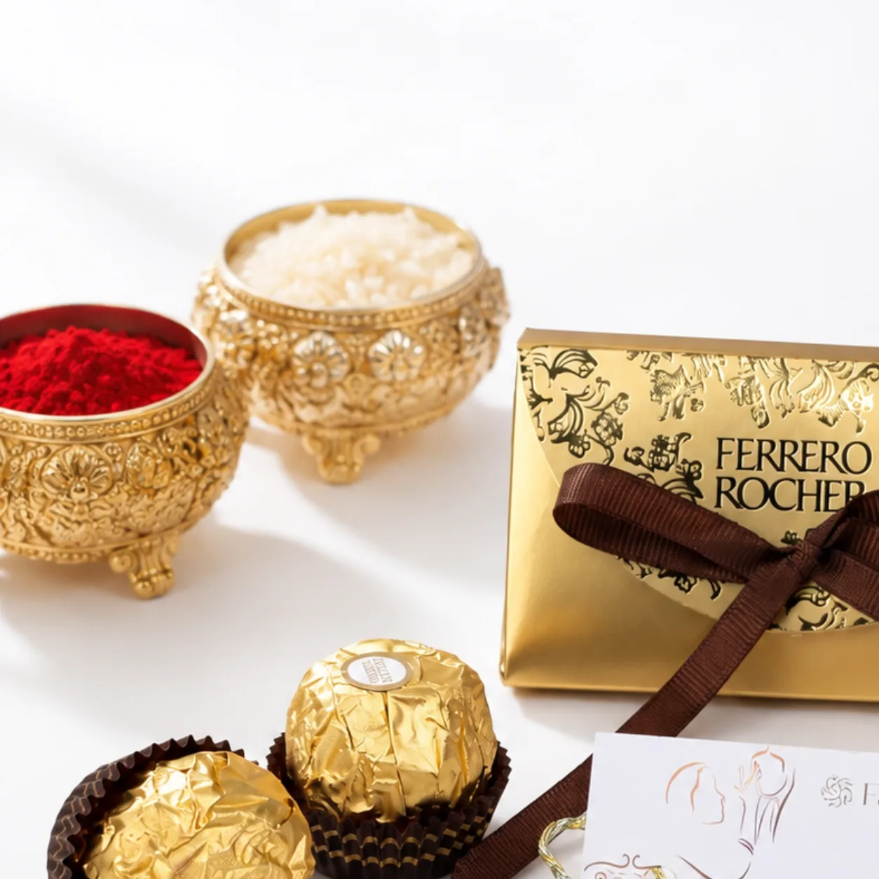 Elegant Om-design Rakhi arranged with Ferrero Rocher treats and traditional Raksha Bandhan essentials.