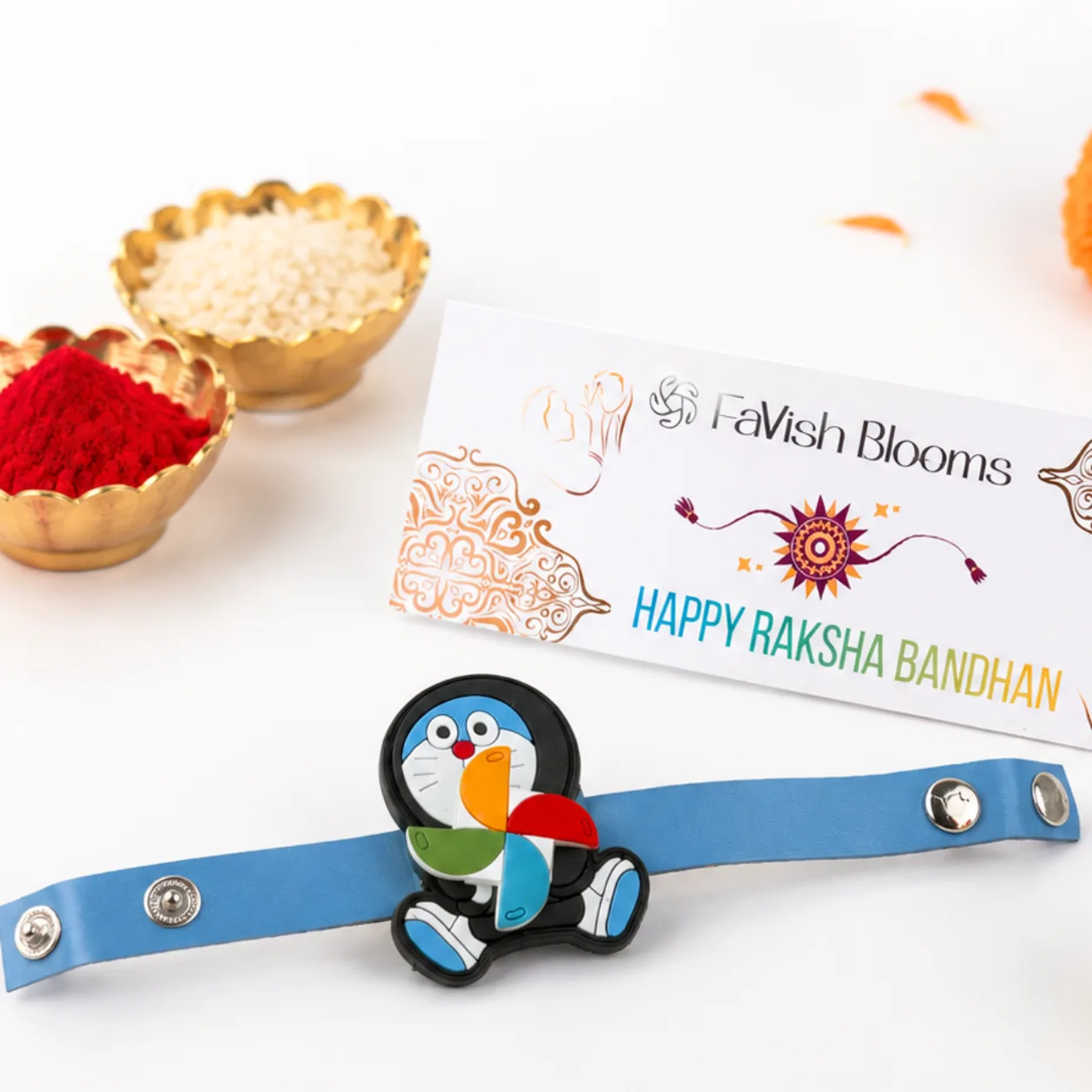 Doraemon spinner Rakhi gift set with Lord Ganesha idol, kumkum, and rice for kids’ Raksha Bandhan gifting.