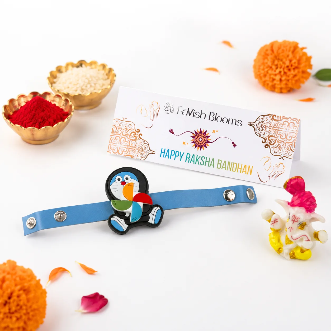 Doraemon spinner kids Rakhi with decorative Lord Ganesha idol, roli, and chawal for Raksha Bandhan.