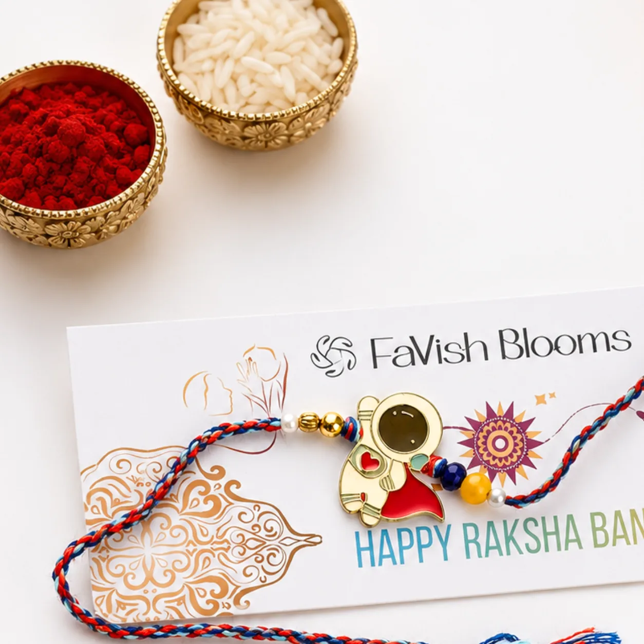 Kids astronaut Rakhi displayed in a festive Raksha Bandhan setup with roli and chawal.