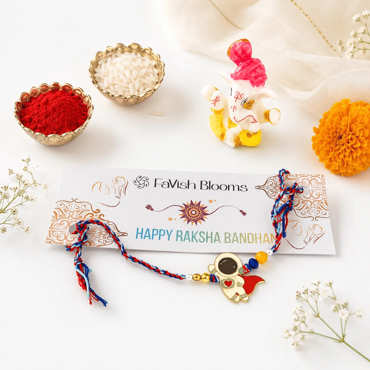 Astronaut Design Kids Rakhi with Ganesha Idol, roli, chawal, and Raksha Bandhan greeting card