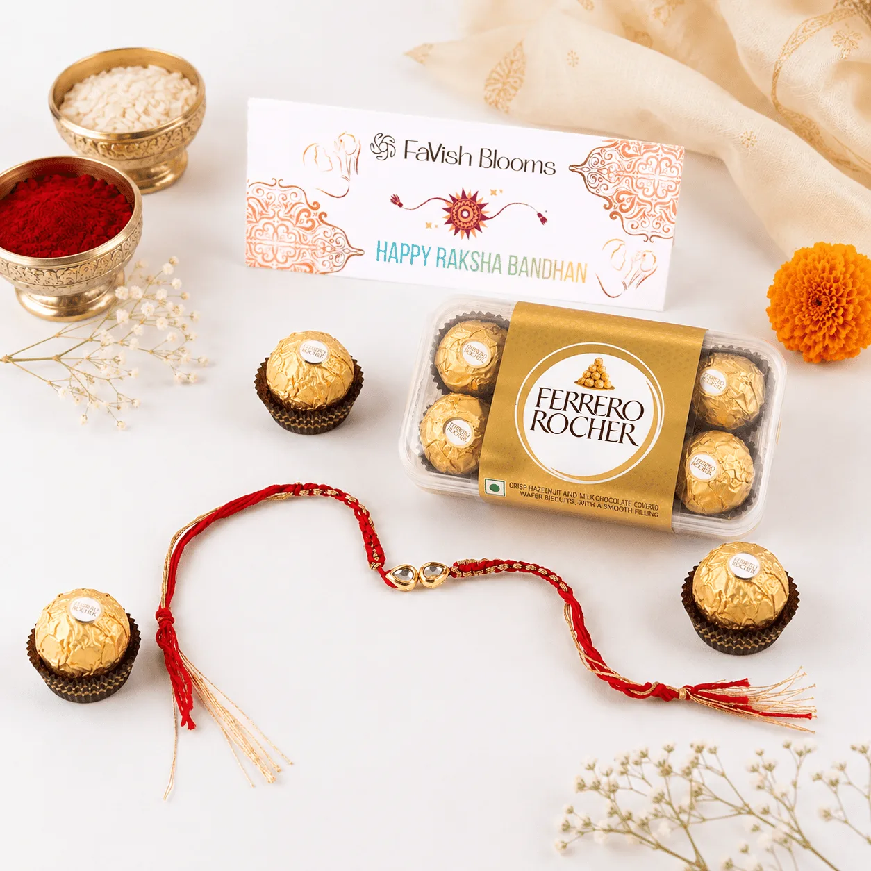 Rakhi thread with Ferrero Rocher chocolates and a "Happy Raksha Bandhan" card from FaVish Blooms.