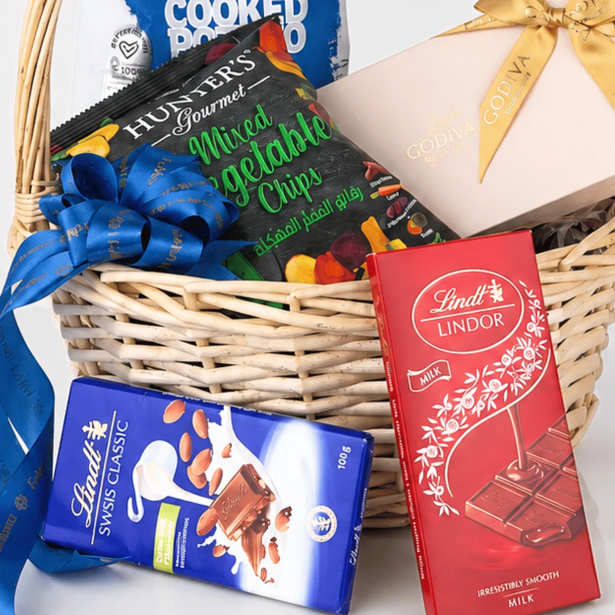 Luxury floral gift basket featuring Godiva chocolates, Lindt treats and beautiful blooms