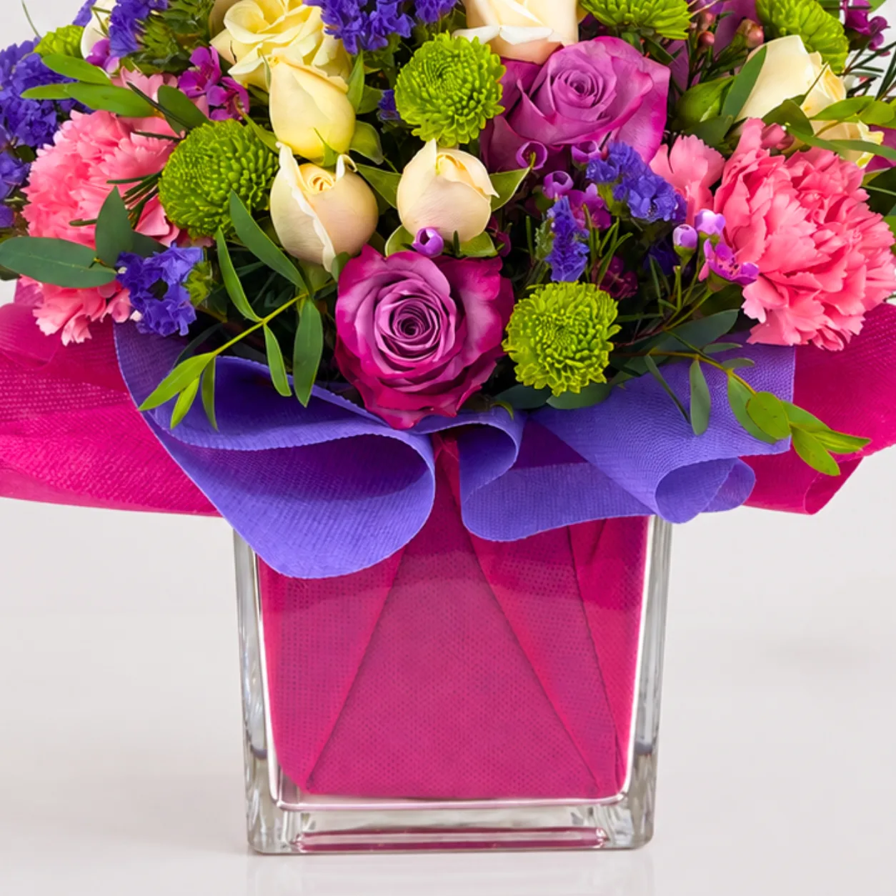 Colorful birthday flower arrangement in a clear glass vase with fresh mixed blooms