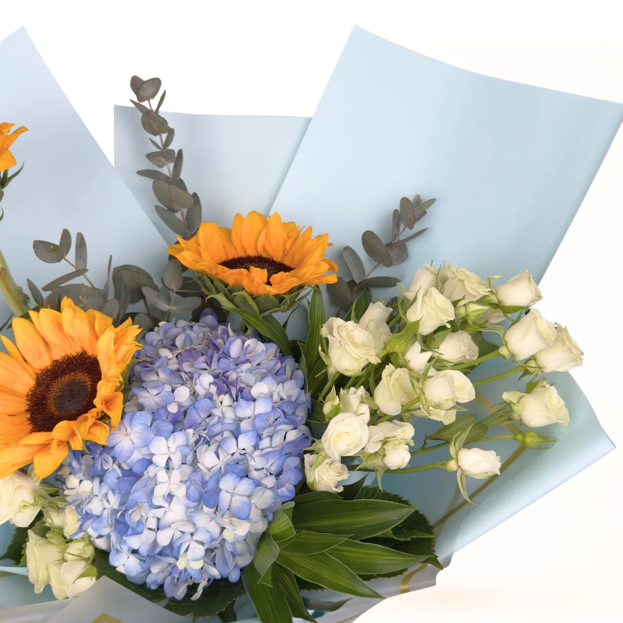 Fresh mixed flower bouquet featuring sunflowers, blue hydrangeas and decorative foliage