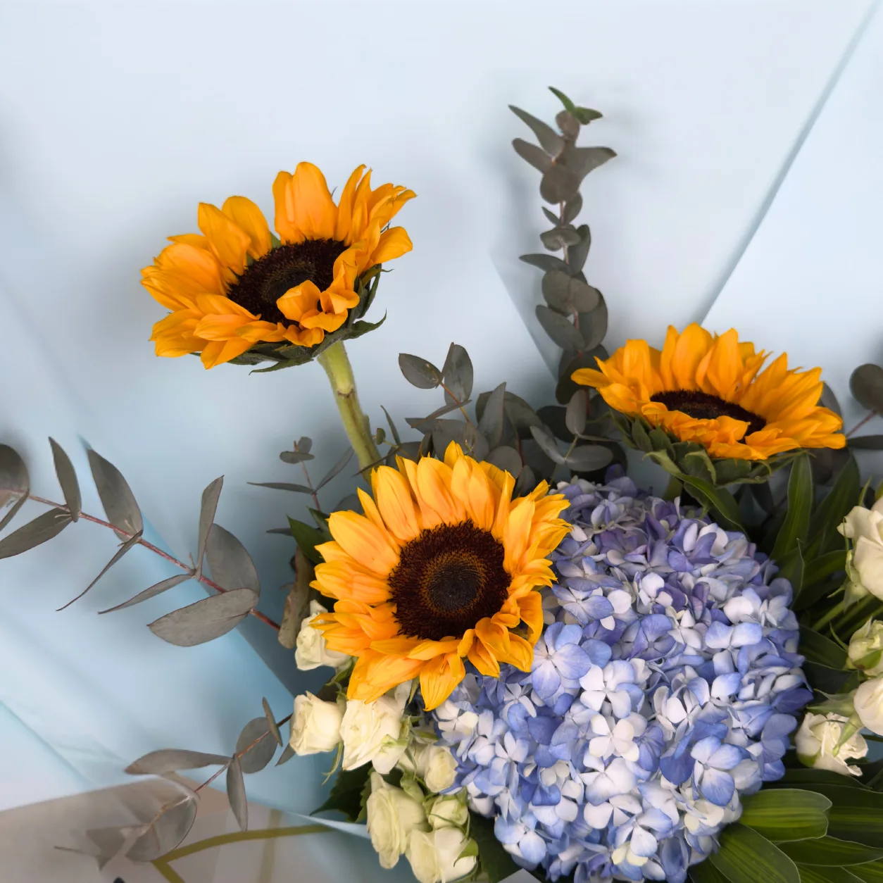 Premium Sunflower & Blue Hydrangea Bouquet with radiant yellow blooms, soft blue flowers and elegant greenery
