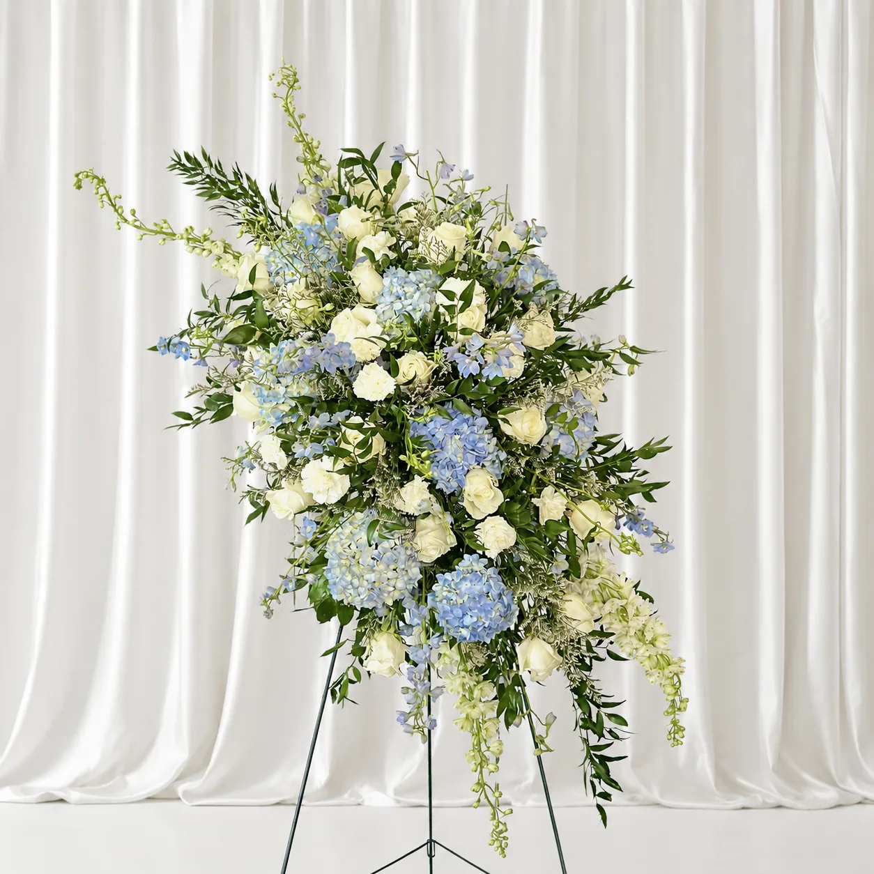 Grand floral stand with blue hydrangeas, white roses and delphiniums for weddings, events and celebrations
