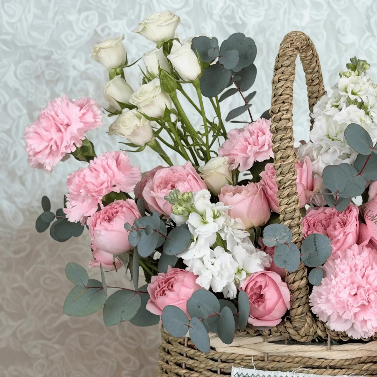 Fresh Juliette roses and matthiola beautifully arranged in a decorative flower basket.