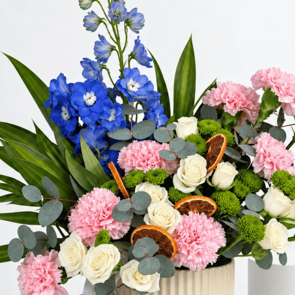 Pastel floral arrangement in a cream pot with a white ribbon for thank-you and teacher appreciation gifts.