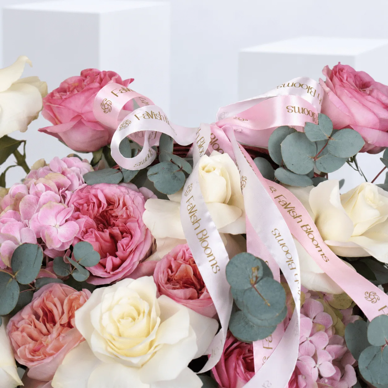 The Secret Garden Rose Basket with 9 pink garden roses, 9 ivory-white roses, 3 pink hydrangeas and eucalyptus greenery.