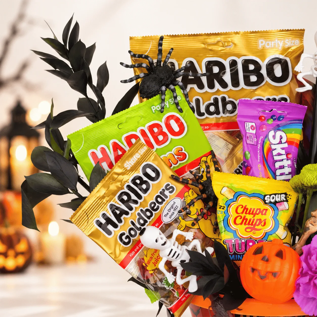 Close-up of Halloween Candy & Fresh Flower Gift Bucket highlighting fresh floral details, assorted sweets, and spooky Halloween accents.