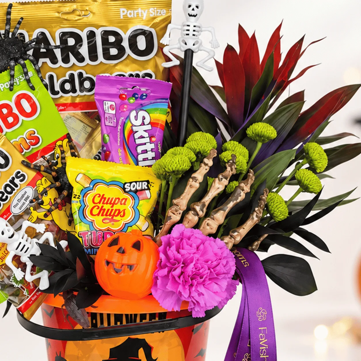 Halloween Candy & Fresh Flower Gift Bucket with vibrant flowers, tempting candies, and festive decorations, available at FaVish Blooms Dubai.