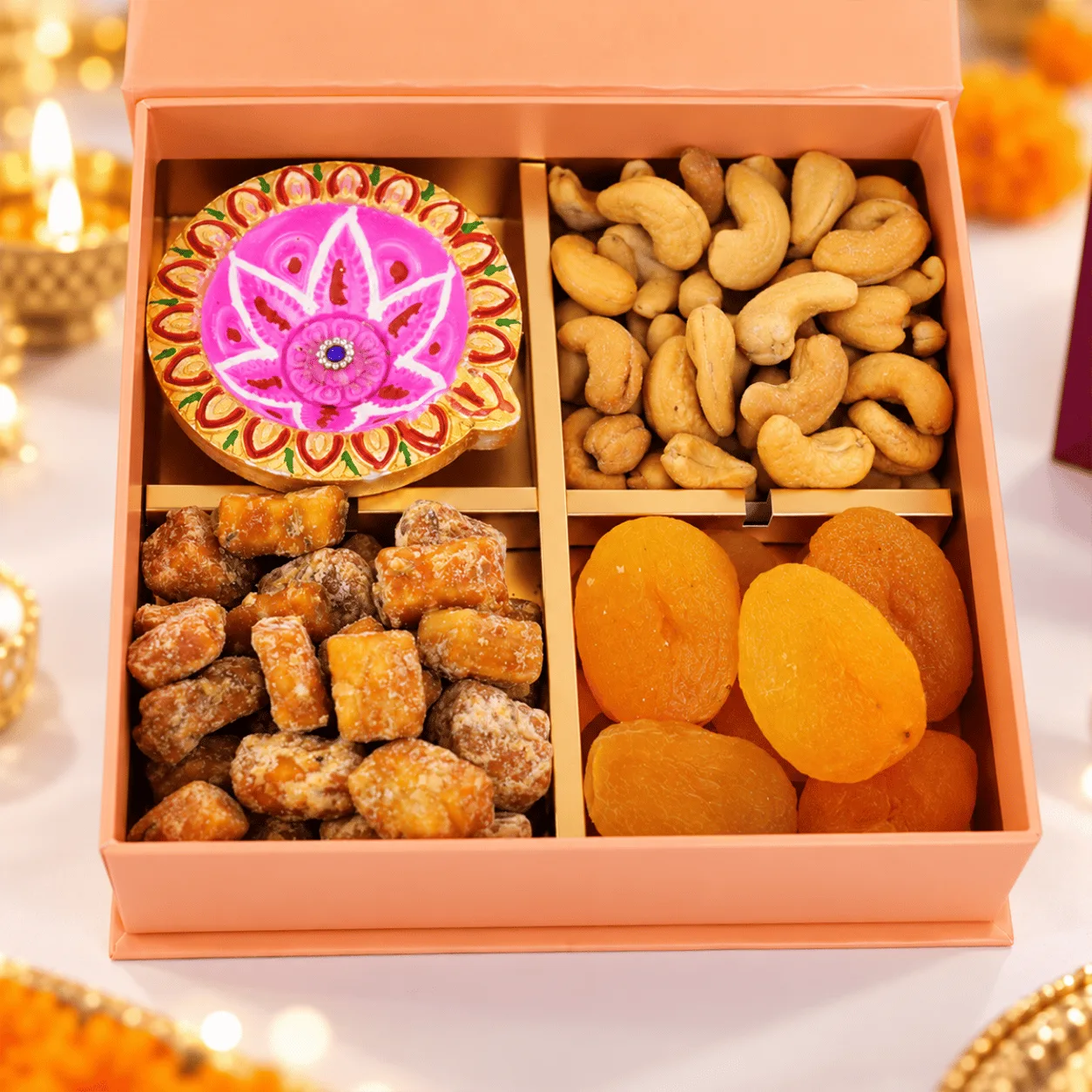 Close-up of premium dry fruits beautifully arranged in a Diwali gift box with traditional diya decorations.