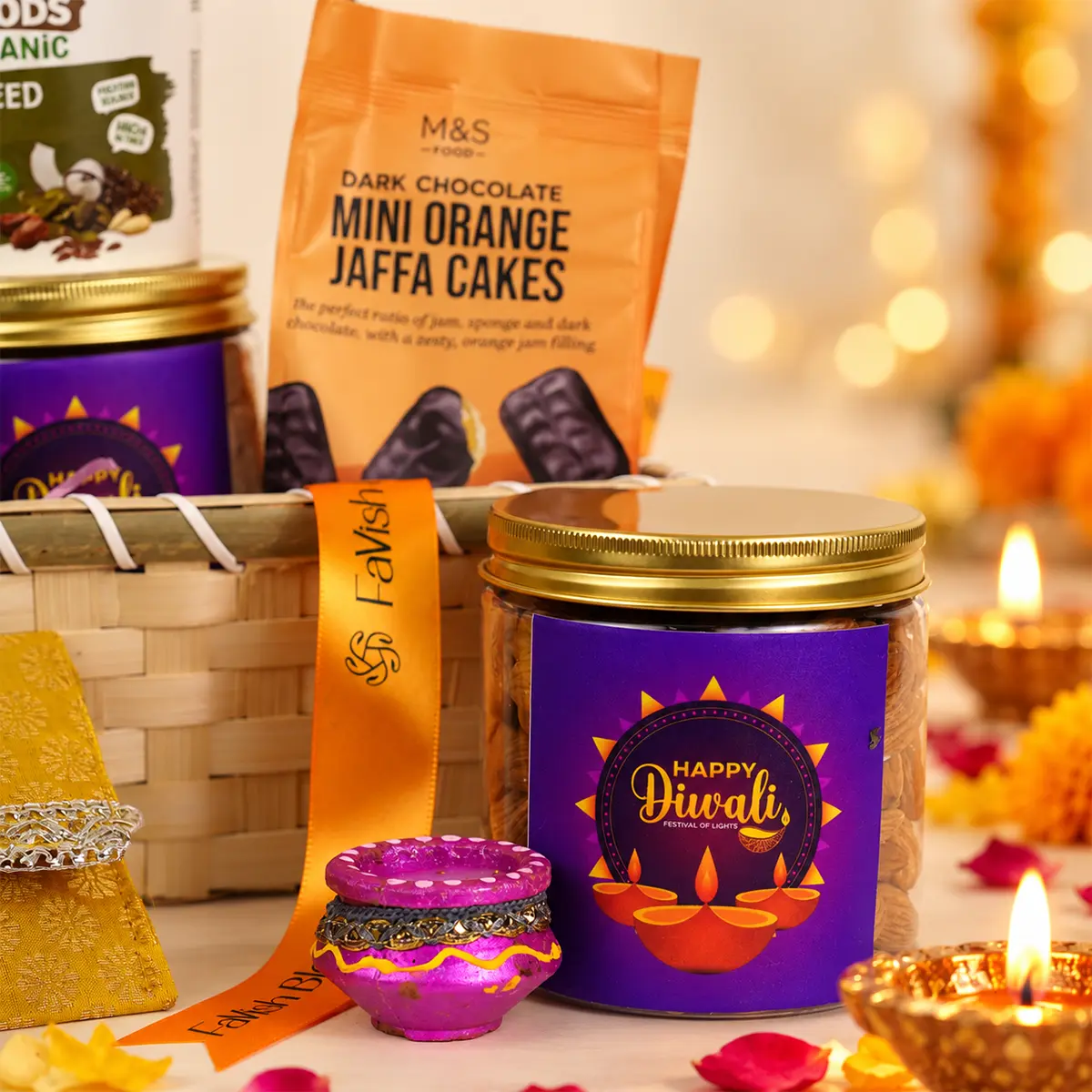 Close-up of Diwali gift hamper featuring chocolate treats, premium dry fruits, and decorative diya.