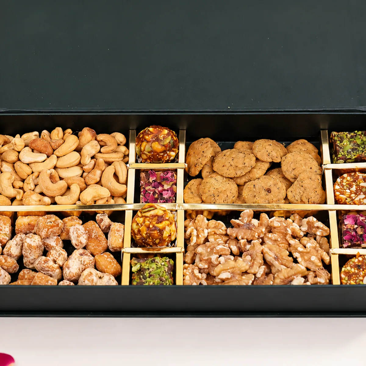 Premium Diwali hamper featuring roasted cashews, walnuts, traditional sweets, and cookies.