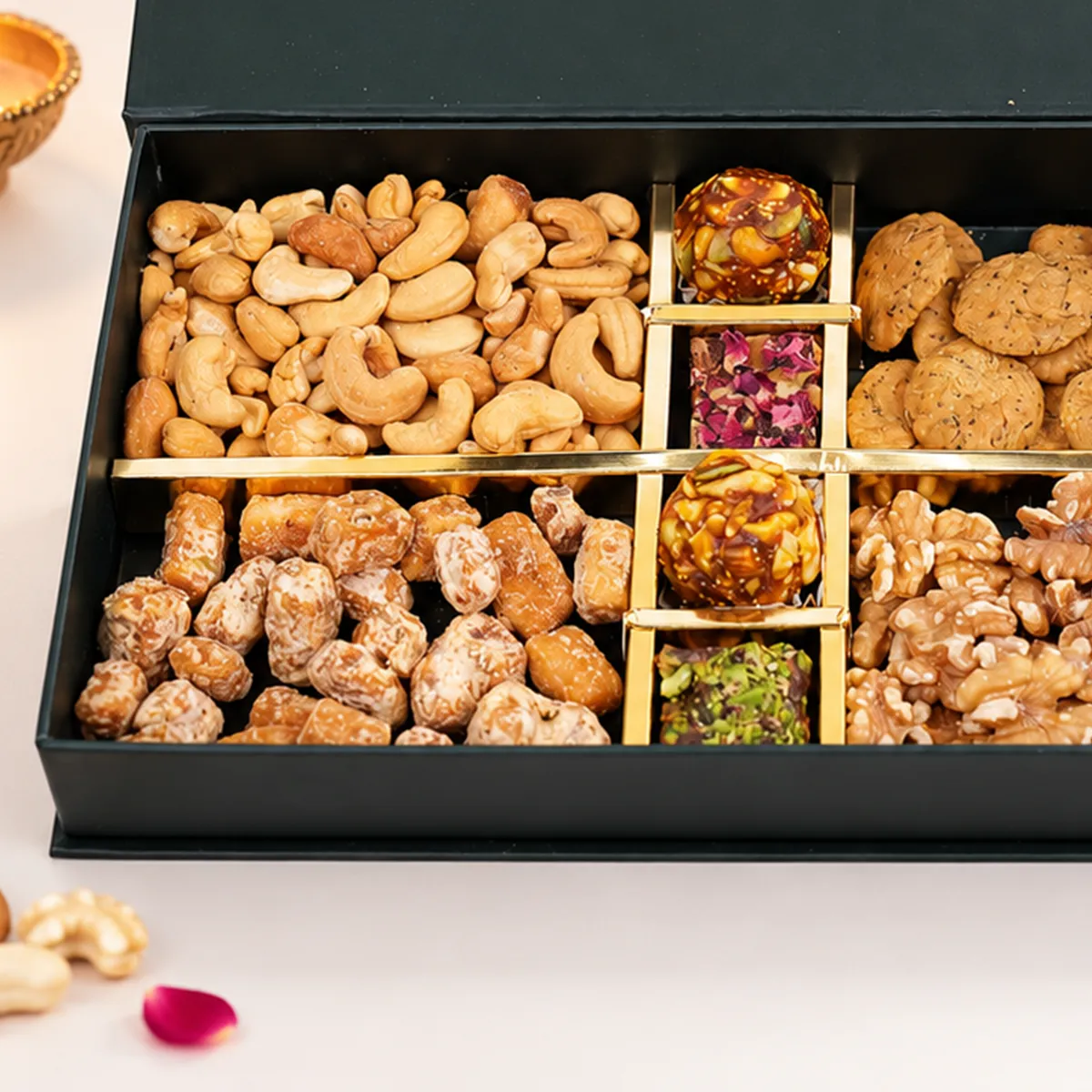 Close-up of Diwali dry fruits gift box with cashews, gurpara, walnuts, and festive mithai.