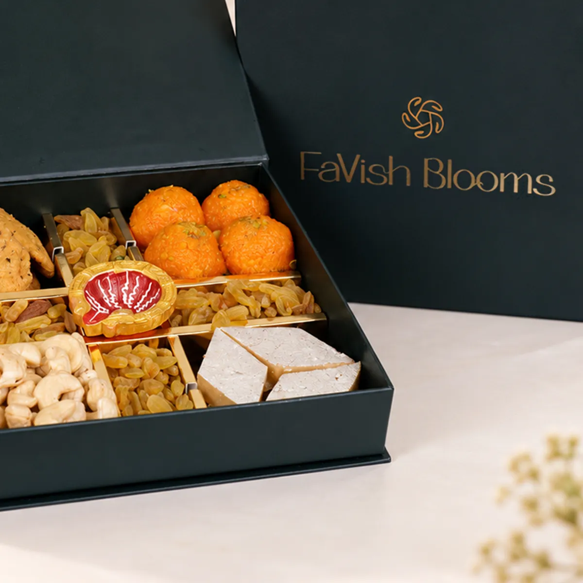 Close-up of FaVish Blooms Diwali gift box with motichoor laddoos, kaju katli, and dry fruits.