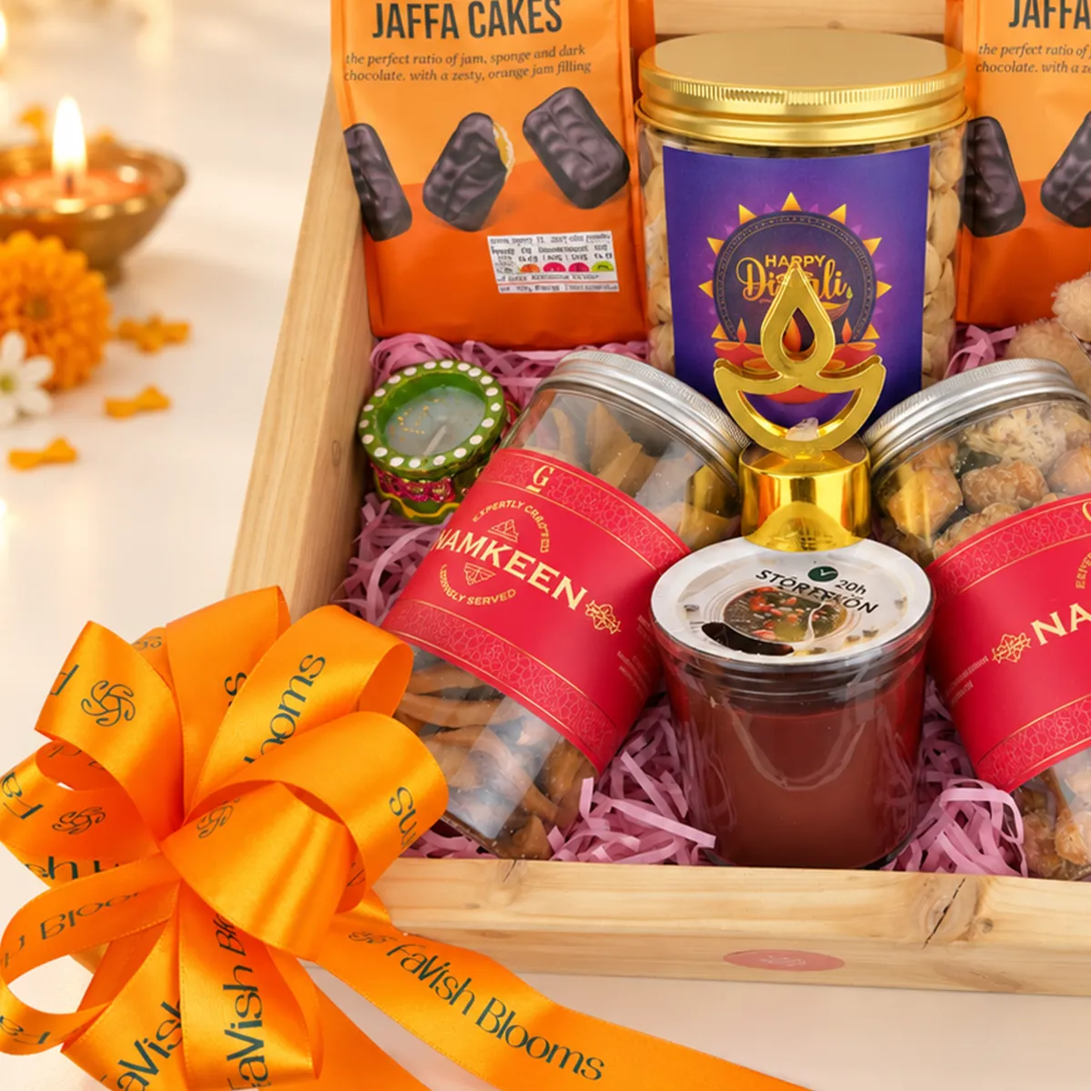 Close-up of luxury Diwali hamper featuring namkeen jars, chocolate treats, decorative diya, and festive packaging.