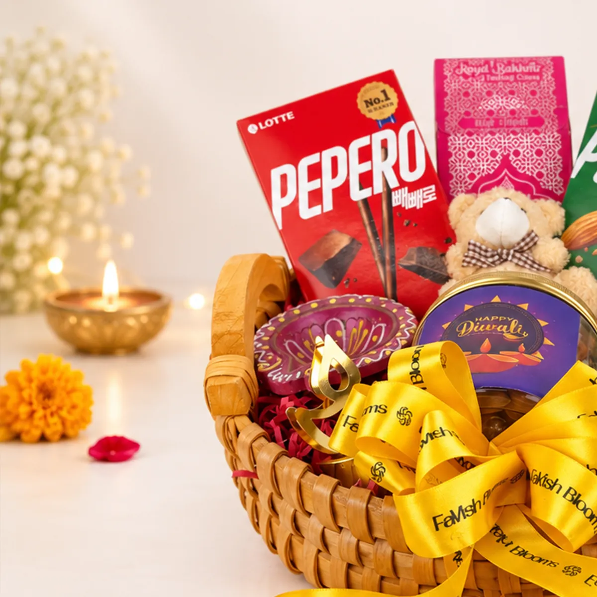 Luxury Diwali chocolate hamper with Pepero sticks, festive sweets, teddy bear, and FaVish Blooms ribbon.