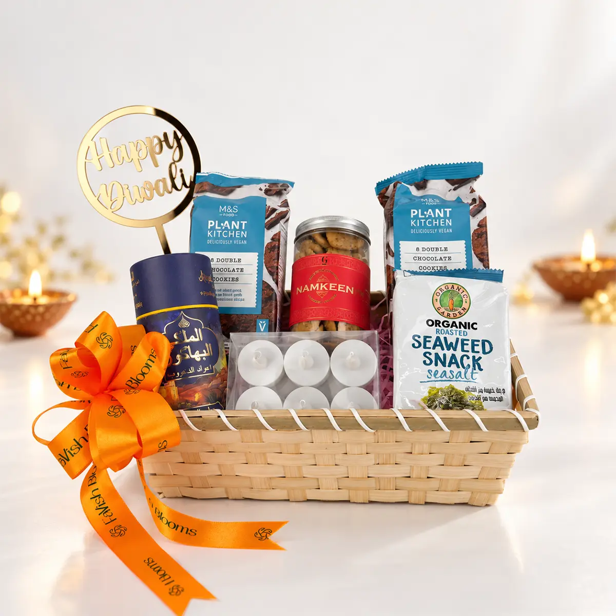 Premium Diwali gift basket with vegan chocolate cookies, namkeen, roasted seaweed snacks, tealight candles, and a Happy Diwali topper, decorated with a FaVish Blooms ribbon.