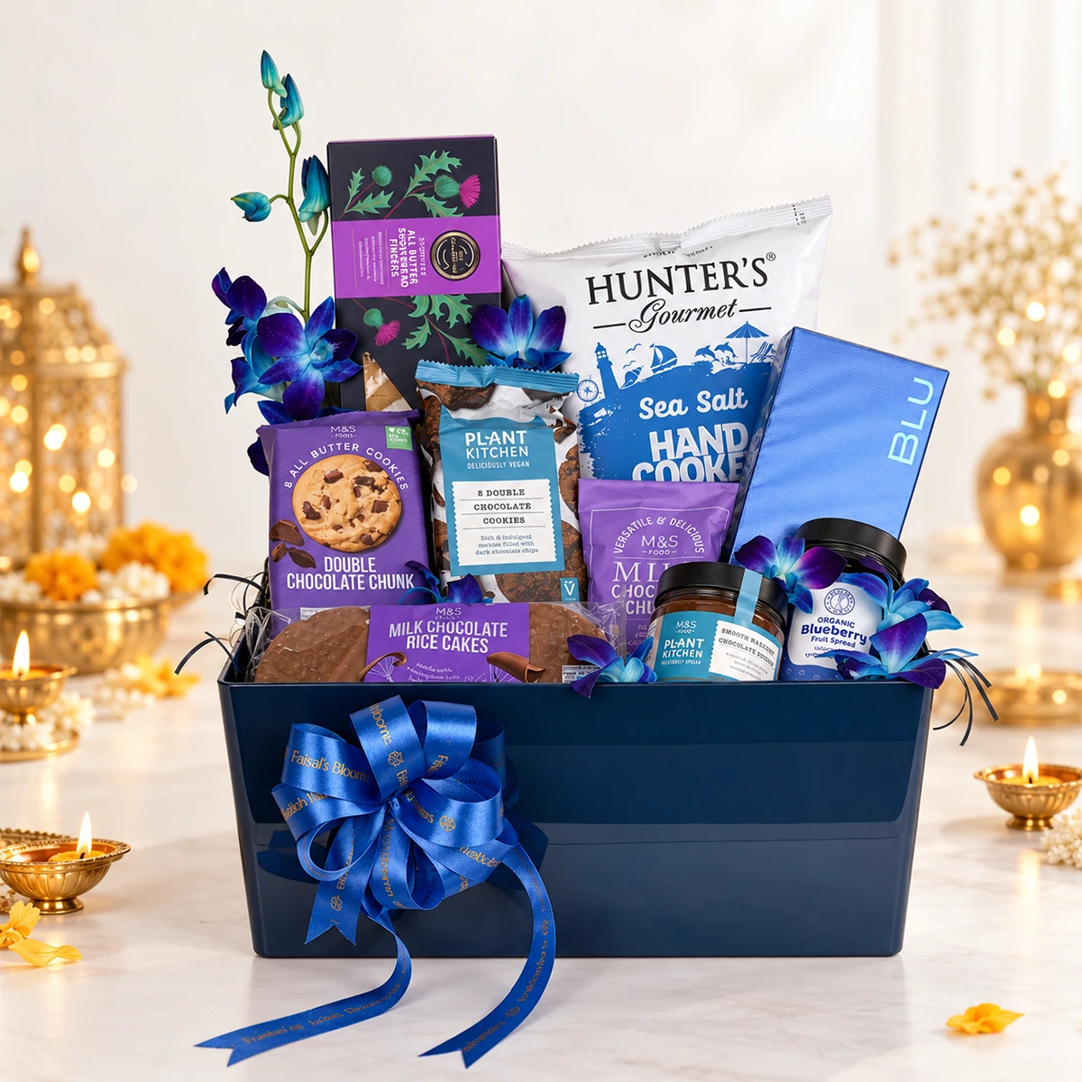Luxury gourmet gift hamper featuring assorted chocolates, cookies, blueberry spread, and blue orchids in an elegant navy blue gift box.