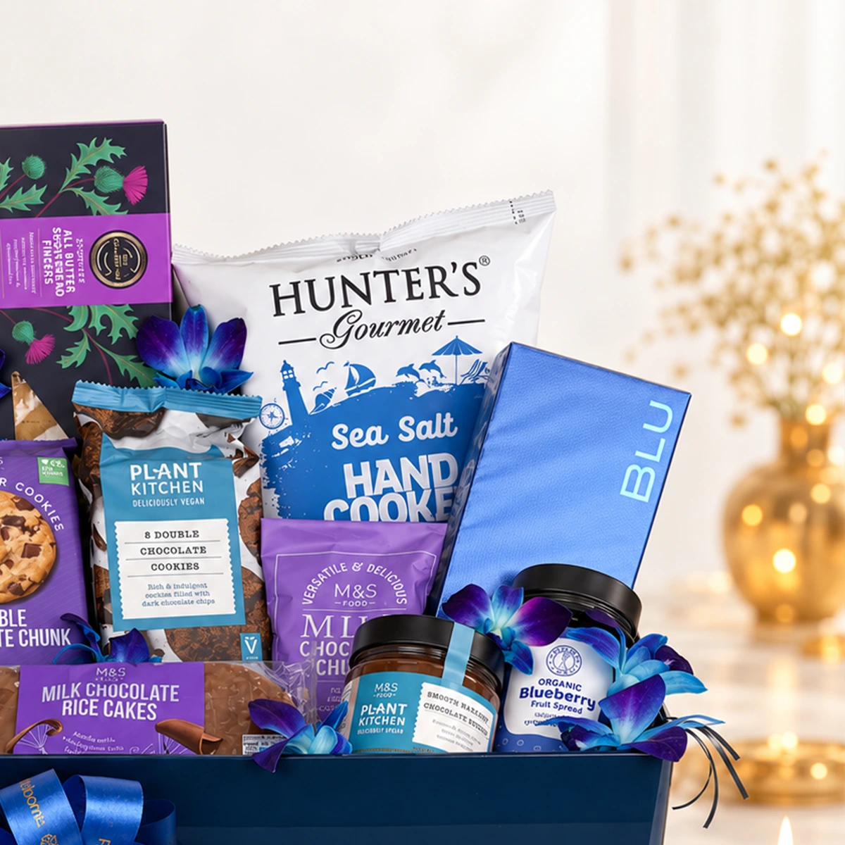 Premium chocolate gift basket featuring organic blueberry spread, chocolate hazelnut spread, cookies, and decorative blue orchids.