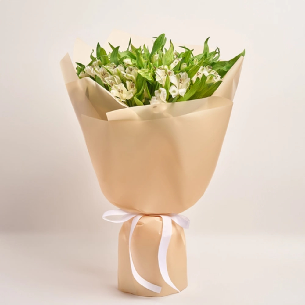 White lily bouquet wrapped in elegant beige paper with a satin ribbon