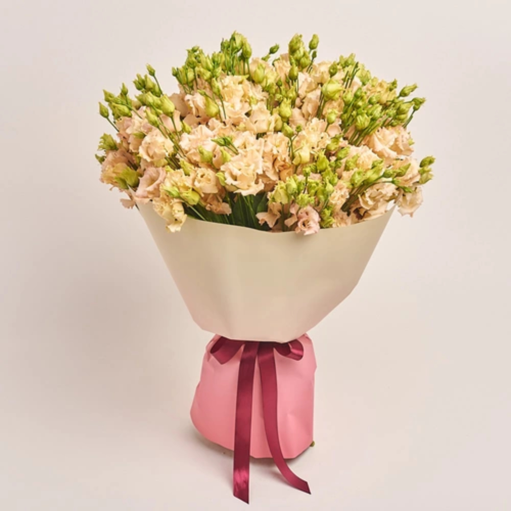 Peach lisianthus bouquet wrapped in beige paper with a pink satin ribbon