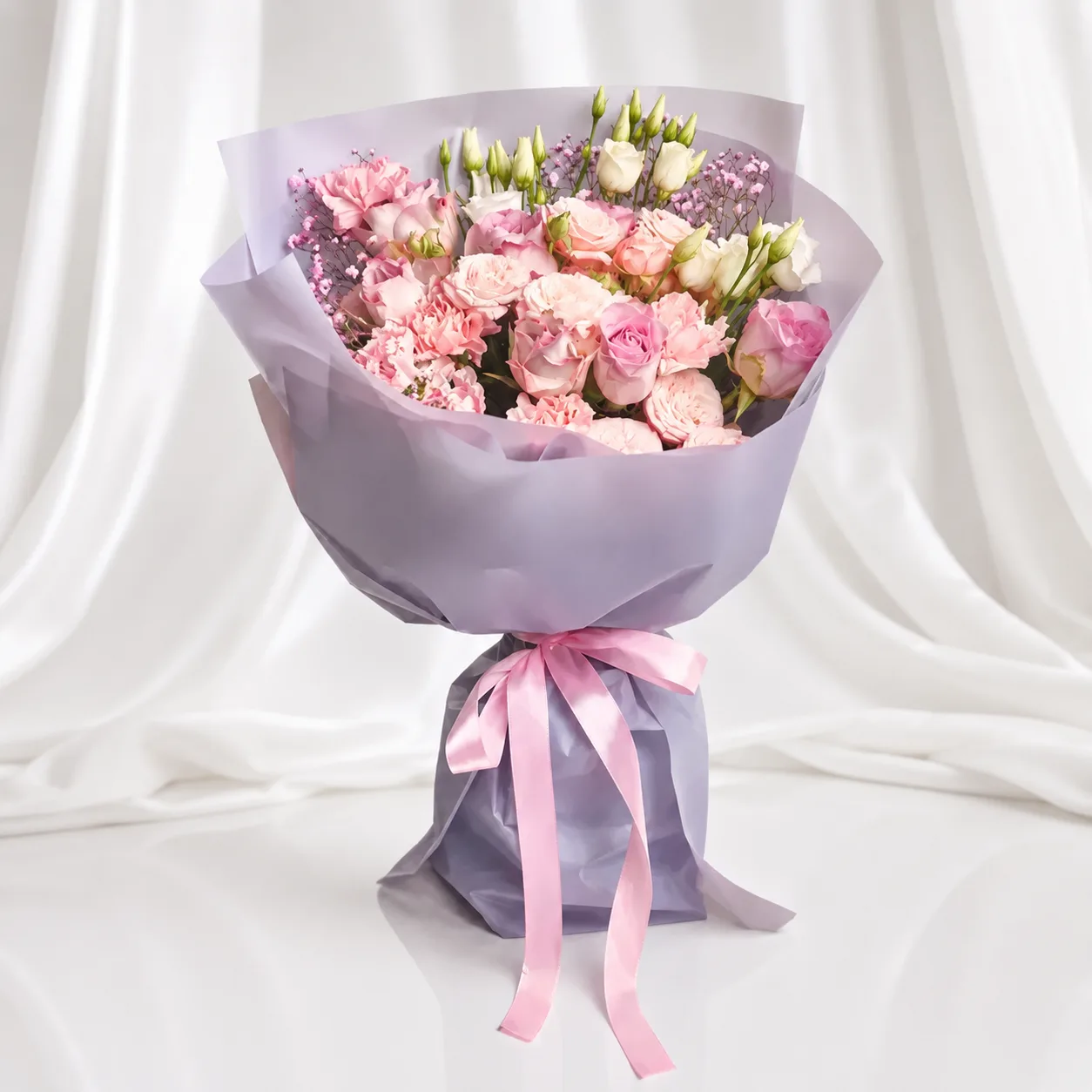 Premium mixed flower bouquet with pink roses, carnations, and white buds wrapped in grey paper with a pink ribbon, elegant floral gift by Favish Blooms Dubai
