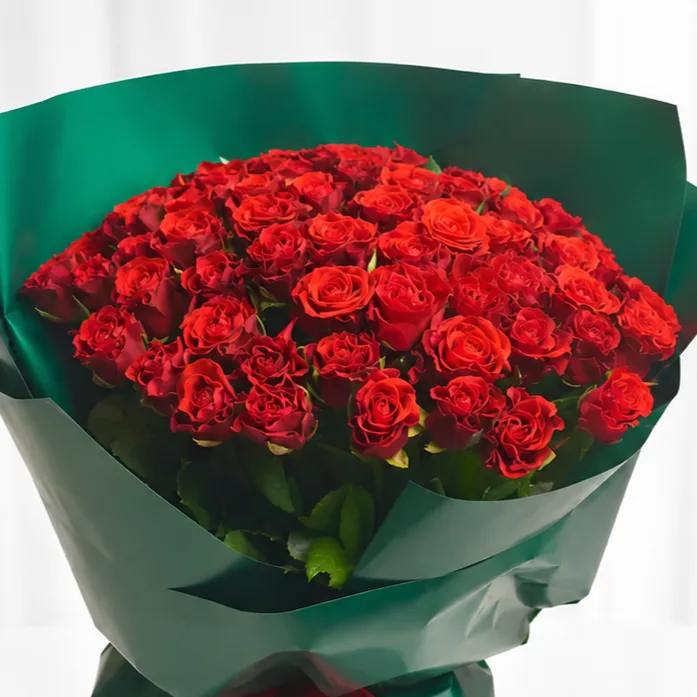 Luxury bouquet of fresh red roses wrapped in premium green paper with a red ribbon, elegant romantic flower gift by Favish Blooms Dubai