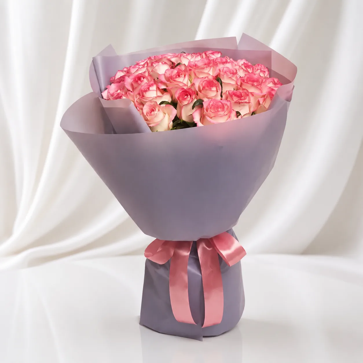 Luxury bouquet of pink and white roses wrapped in elegant grey paper with a satin pink ribbon, premium floral gift by Favish Blooms Dubai