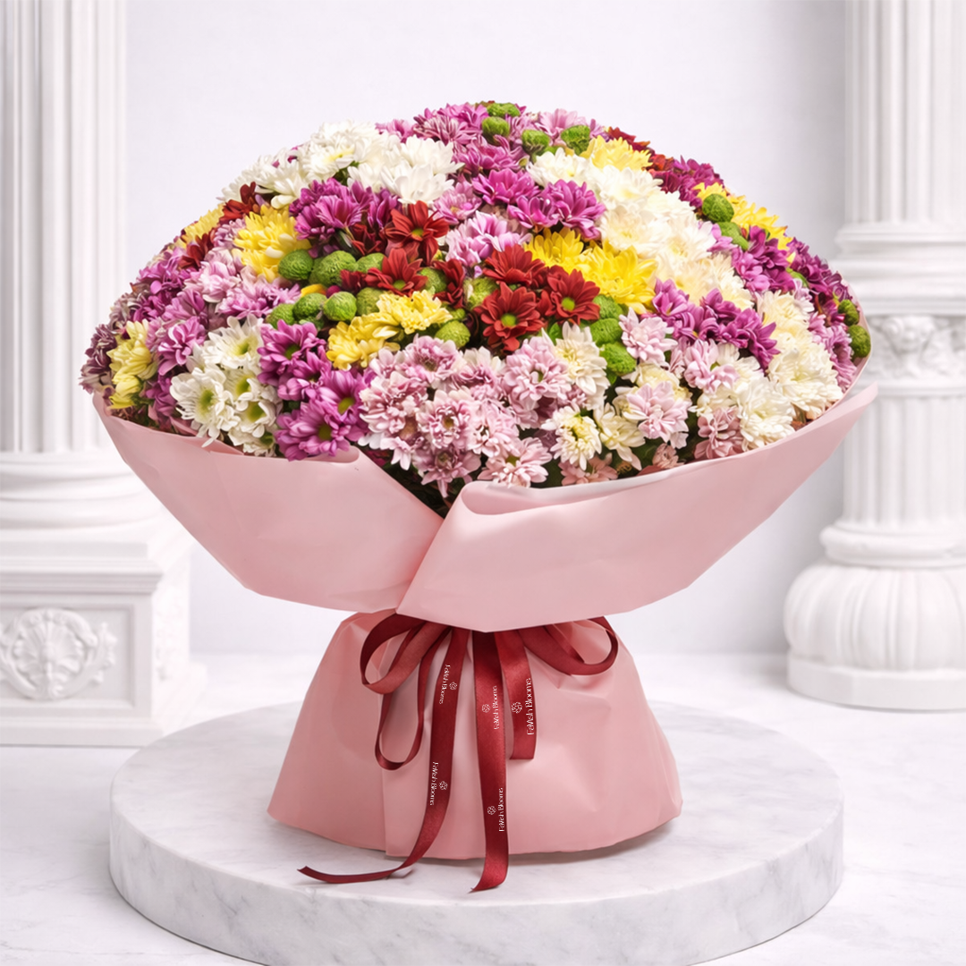 A large bouquet of mixed colorful chrysanthemums wrapped in pink paper, tied with a red branded ribbon.