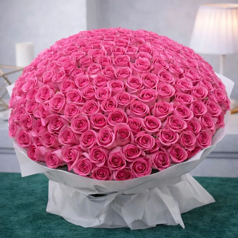 Oversized luxury bouquet of pink roses wrapped in white paper.