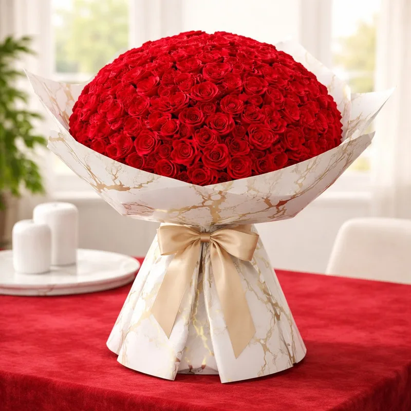 Luxury oversized red rose bouquet wrapped in white and gold marble paper tied with a gold bow.