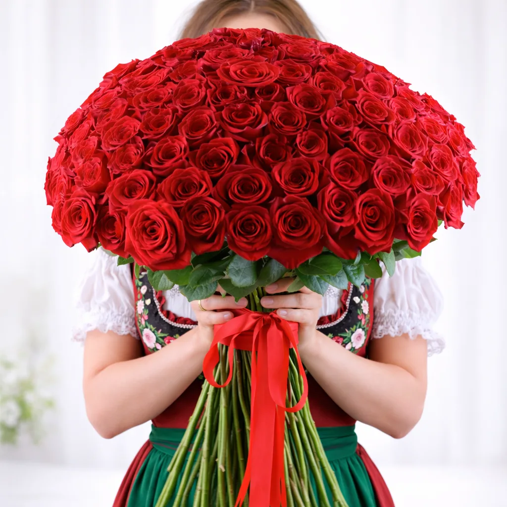 Woman holding large round red rose bouquet with ribbon