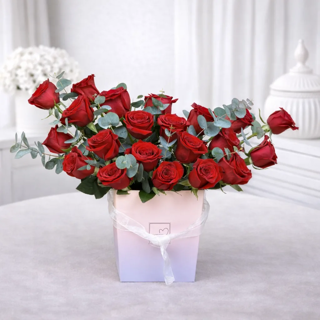 Red rose arrangement with eucalyptus in pastel square flower box