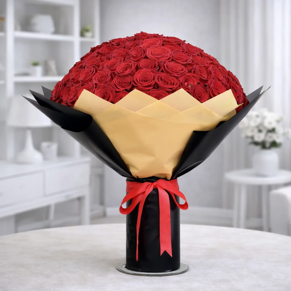 Large round bouquet of red roses wrapped in black and gold paper